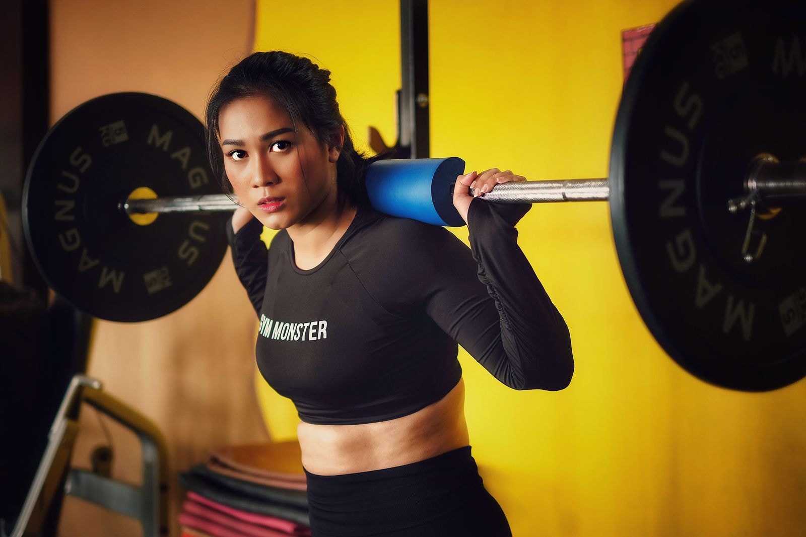 A woman in a squat rack with the bar on her back