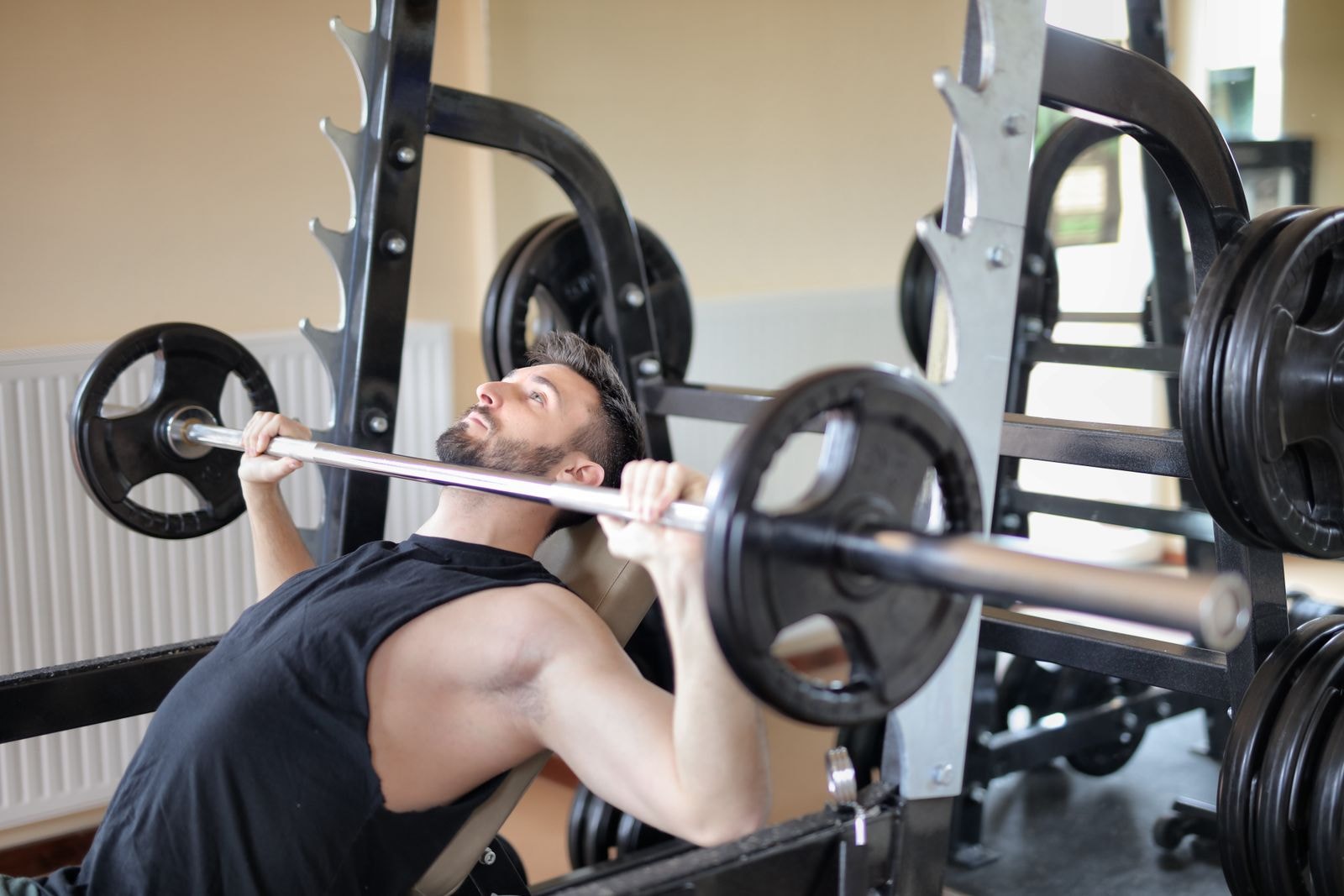A member pressing a loaded barbell on the bench