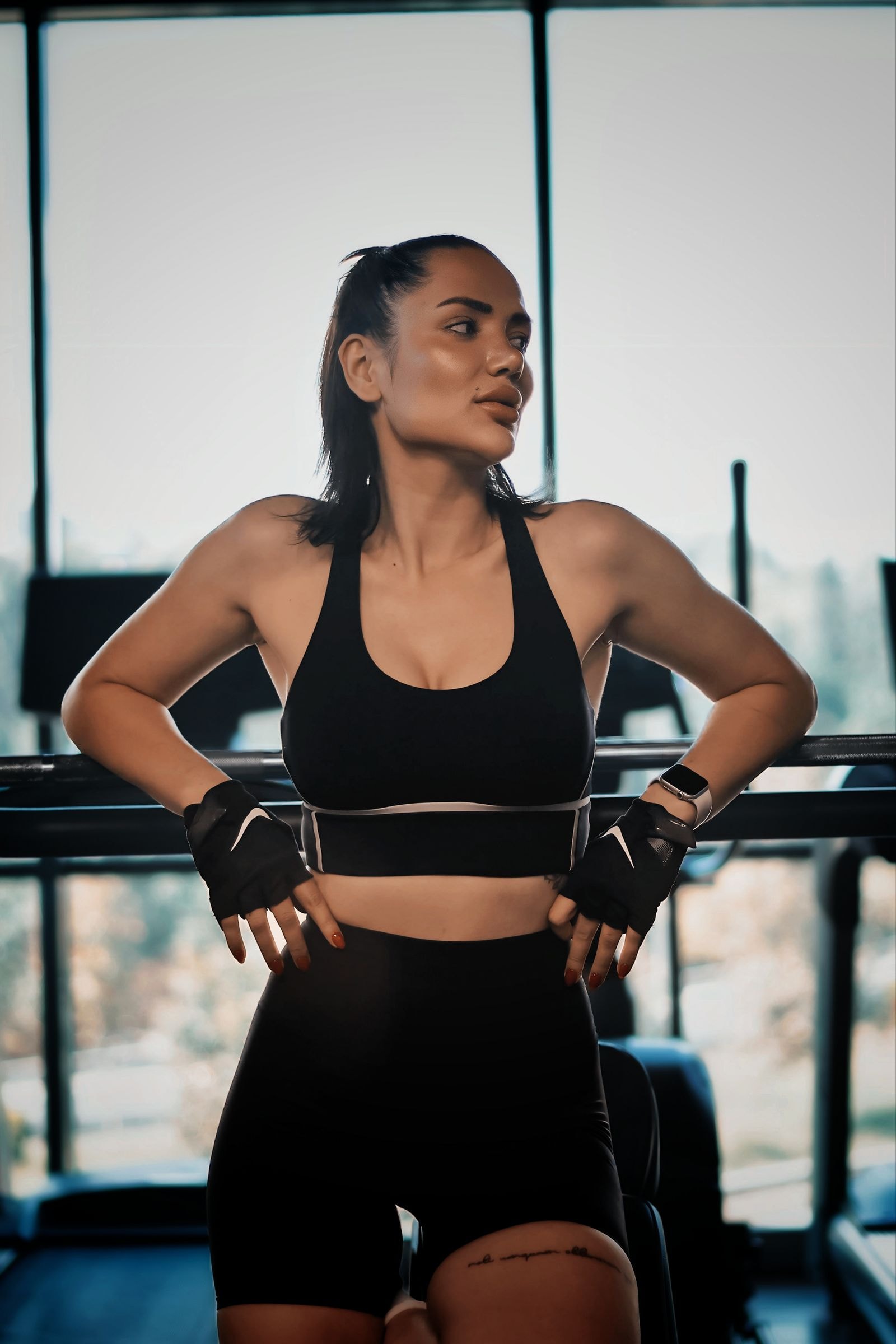 A member in wrist wraps by the gym windows