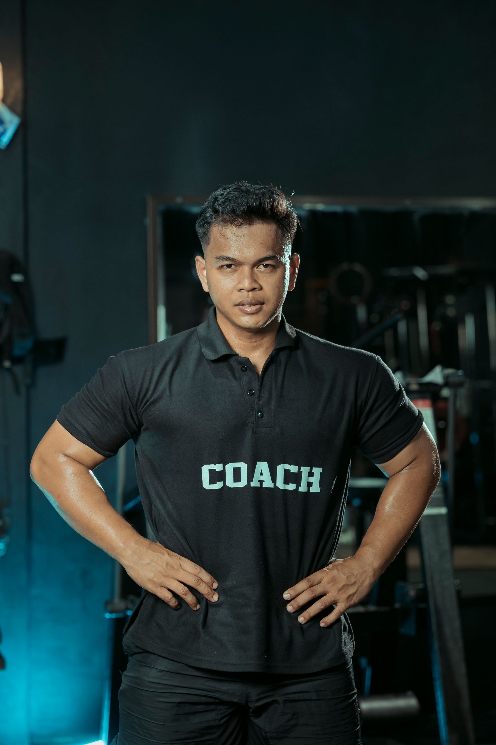 A coach on the gym floor in a coach shirt