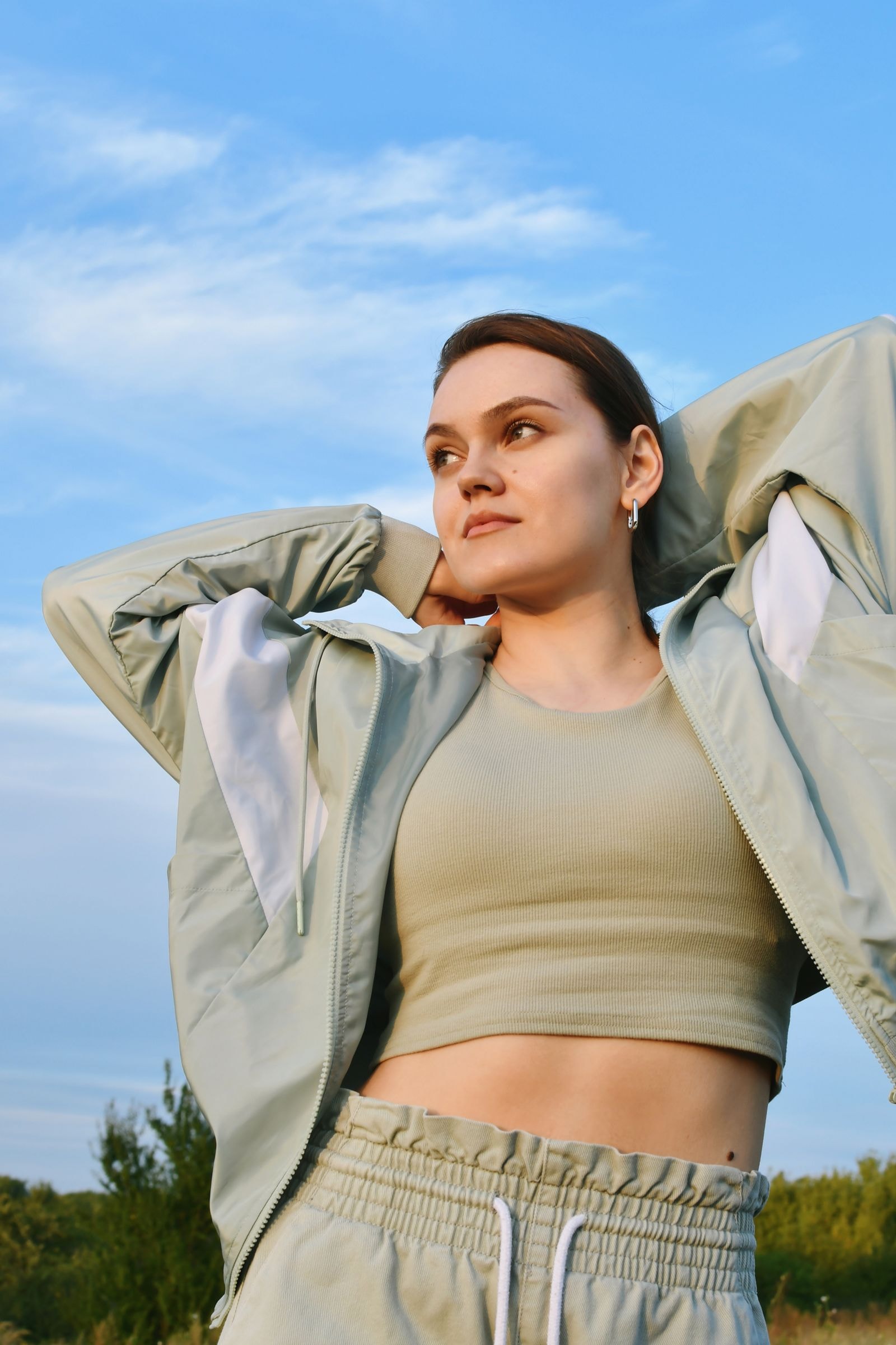 A woman stretching outdoors under a blue sky