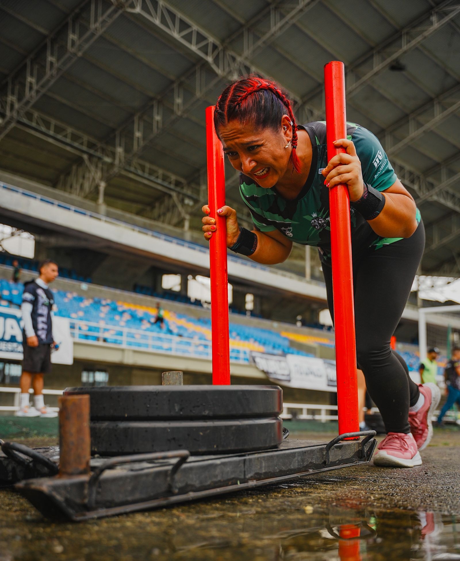 A racer hauling a sled pull in a stadium